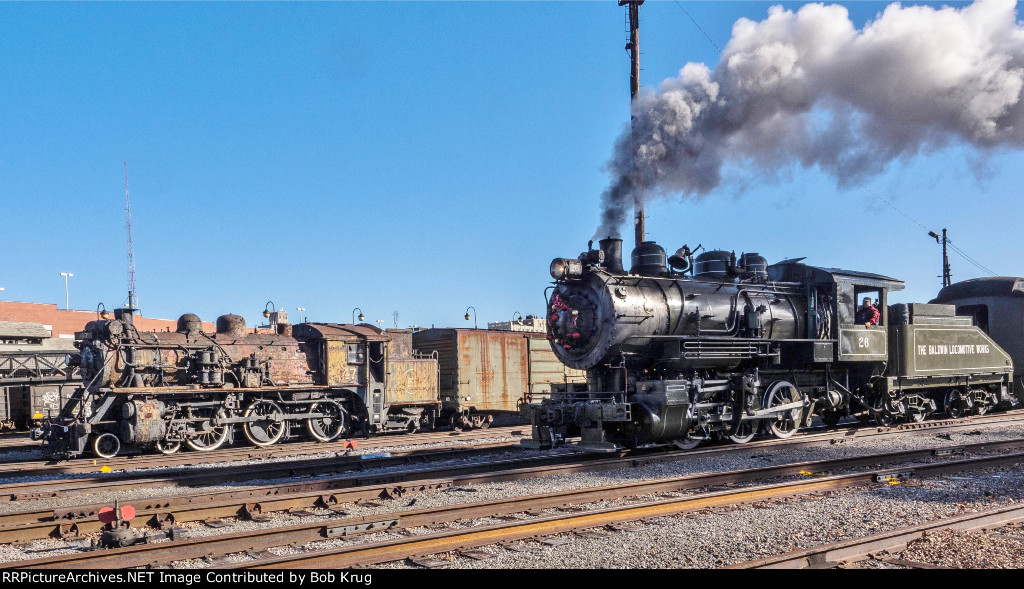 Shiny 0-6-0 steam locomotive 26 passing somewhat less shiny museum piece CN 47 in the Steamtown Yard